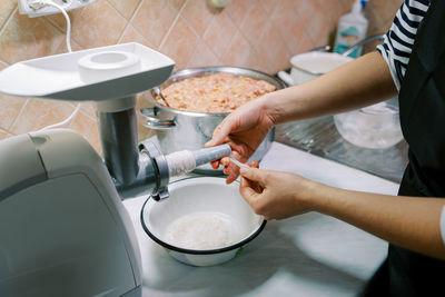 Midsection of woman washing hands in kitchen