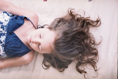 High angle view of girl sleeping on bed