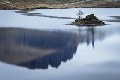 Reflection of trees in lake against sky