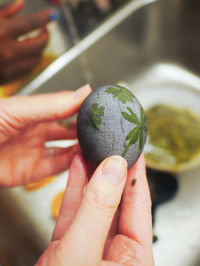 Close-up of hand holding egg being dyed for easter