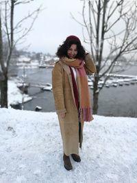 Portrait of smiling woman standing on snow