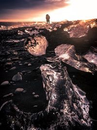 Scenic view of rocks at beach against sky