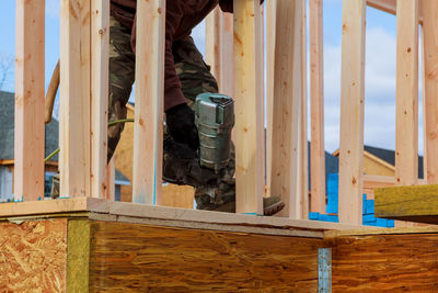 Low section of man drilling wood