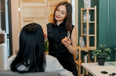 The makeup artist works in her salon, applies professional makeup. beauty industry, make-up