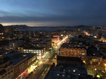 High angle view of illuminated city against sky at dusk