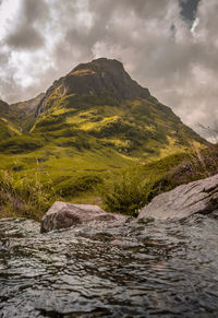 Scenic view of river amidst mountains against sky