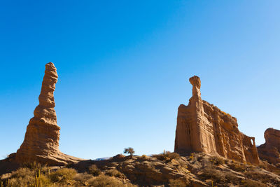 Low angle view of rock formations against blue sky