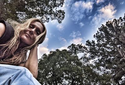 Low angle portrait of woman against plants