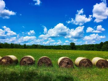 Hay bales on field against sky