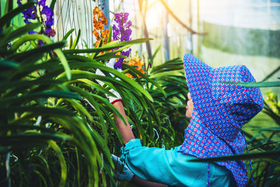 Female researcher examining flowers in greenhouse