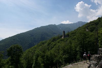 Man walking on mountain against sky