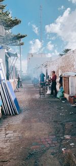 Rear view of people working on street against sky