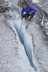 High angle view of woman exploring glacier