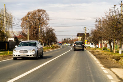 Cars on road against sky in city