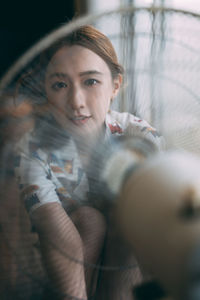 Portrait of young woman sitting at home