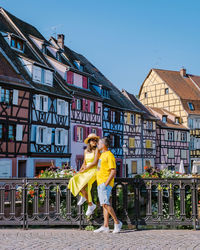 Woman standing by railing against clear sky