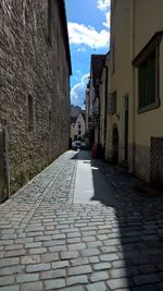 Cobblestone street amidst buildings in city