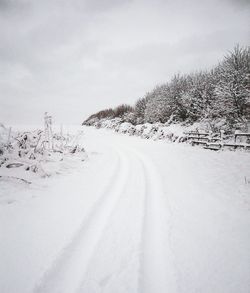 Road passing through snow covered landscape