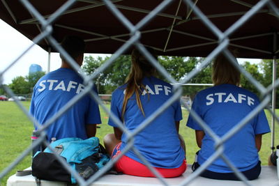 Rear view of boys sitting on soccer field