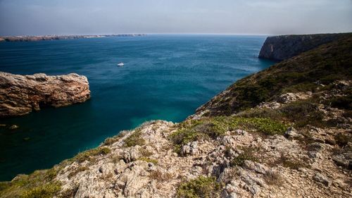 Scenic view of seascape by rock against clear sky