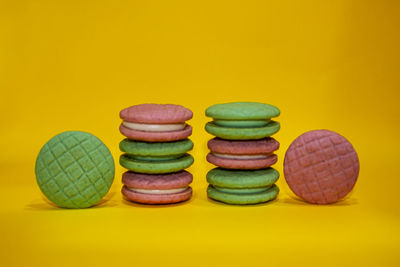 Close-up of multi colored candies against yellow background