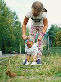 Low angle view of girl playing with doll on grassy field