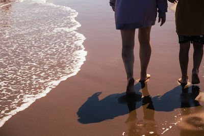 Low section of woman walking at beach
