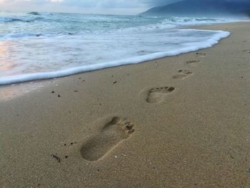 Close-up of sand on beach against sky