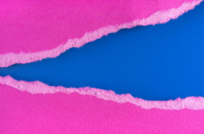 Close-up of pink vapor trail against blue sky