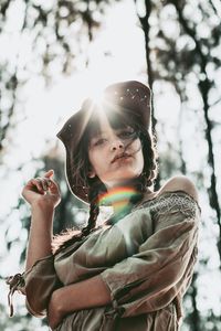 Portrait of young woman against tree