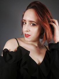 Portrait of beautiful young woman over black background