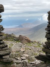 View of rocky coastline against cloudy sky