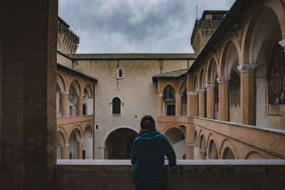 Rear view of woman standing against building