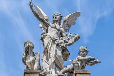 Low angle view of angel statue against blue sky