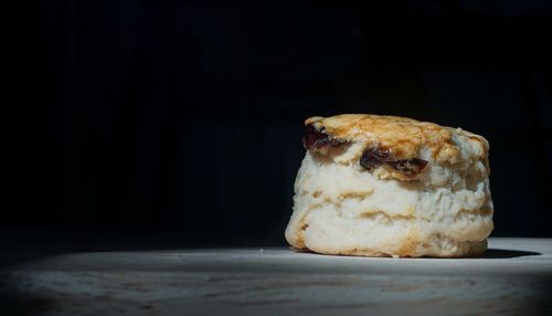 Close-up of cake on table against black background