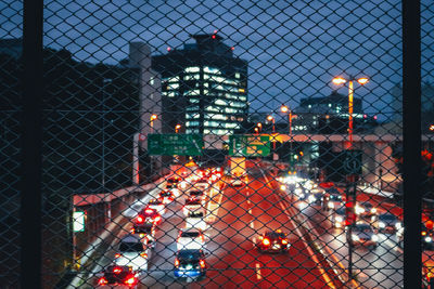 View of chainlink fence with illuminated building in background