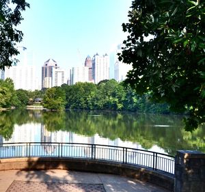 Lake and buildings in city against sky
