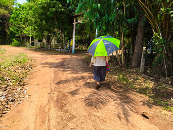 Rear view of woman walking on footpath