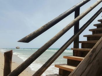 Sea seen through railing against sky