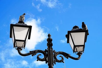 Low angle view of street light against blue sky