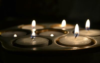 Close-up of lit candle in dark room