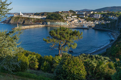 High angle view of townscape by sea against sky