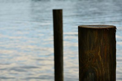 Close-up of wood pilings against water background