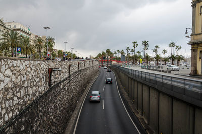 Cars on road in city against sky