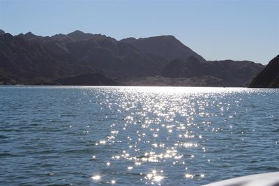 Scenic view of lake by mountains against sky