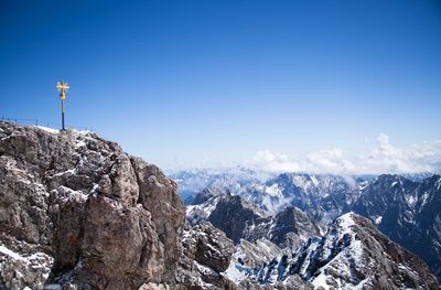 Scenic view of snowcapped mountains against blue sky