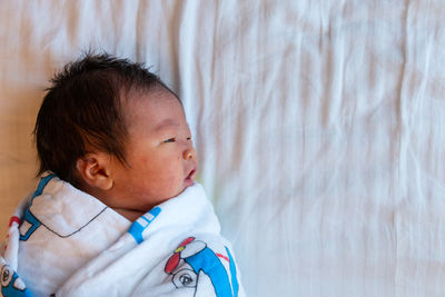 Close-up portrait of cute boy sleeping on bed