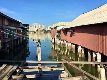 Canal amidst buildings against blue sky