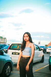 Full length of woman standing in car against sky