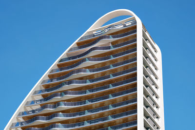 Low angle view of modern building against clear blue sky